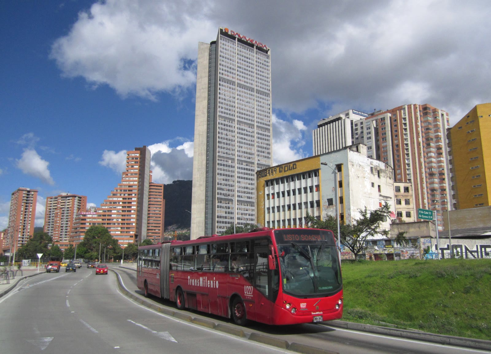 Bus articulado rojo de TransMilenio circulando por la Avenida Caracas en el centro de Bogotá