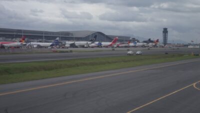 Aviones de varias aerolíneas en la plataforma del Aeropuerto Internacional El Dorado de Bogotá con la terminal y la torre de control al fondo