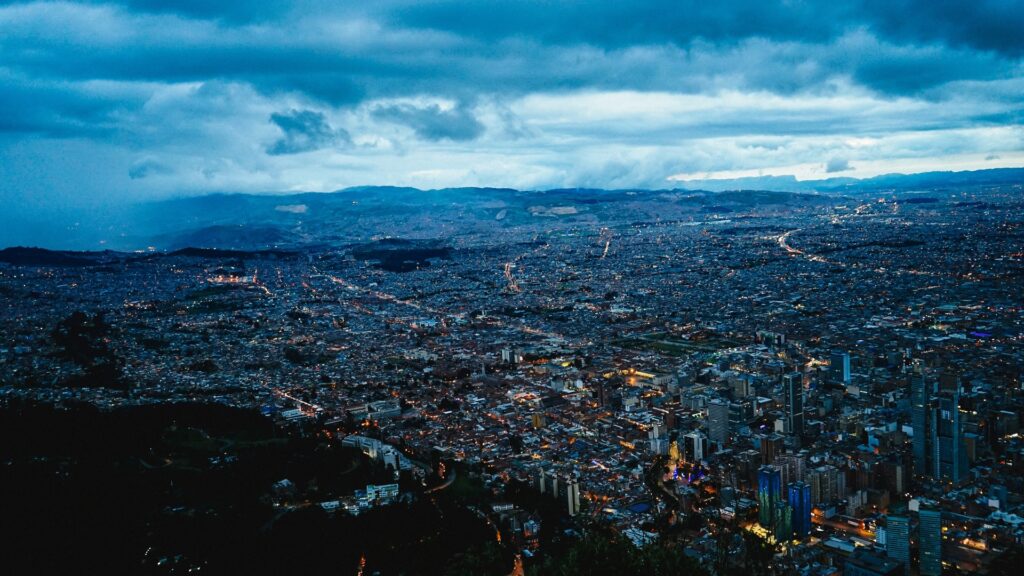 Vista panorámica de Bogotá al atardecer desde Monserrate, con luces de la ciudad sobre la sabana