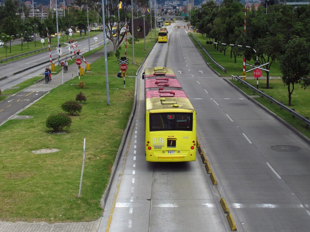 Personas en bicicleta y caminando por la Ciclovía en la calle 26 de Bogotá un domingo