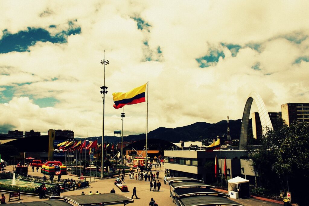 Plazoleta interior de Corferias en Bogotá con una bandera de Colombia y los cerros orientales al fondo