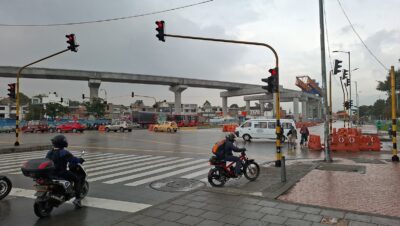 Viaducto elevado de la Línea 1 del Metro de Bogotá en construcción sobre la avenida NQS con avenida Primero de Mayo, con motos y carros en el cruce