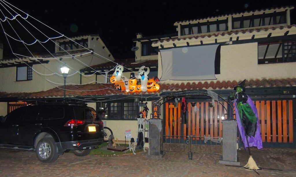 Halloween 2026 en Bogotá: planes, fiestas y eventos 1 Fachada de una casa en Bogotá decorada de noche para Halloween con calabazas inflables, fantasmas, telarañas y una bruja