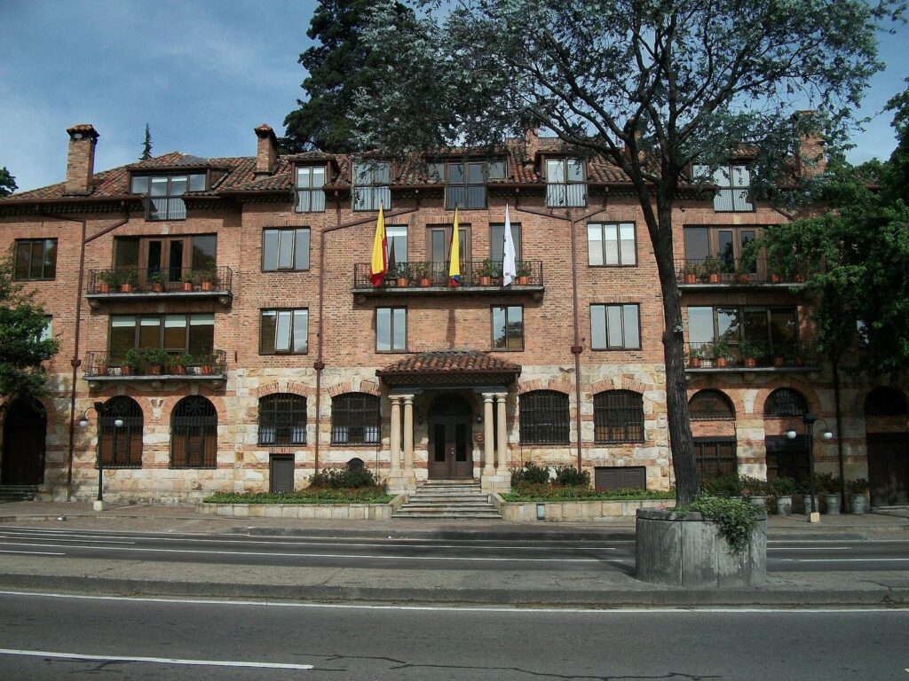 Hoteles con Llave Michelin en Bogotá: los 3 de 2026 1 Fachada de ladrillo y piedra del Hotel Casa Medina sobre la carrera Séptima de Bogotá, con balcones, banderas y árboles al frente