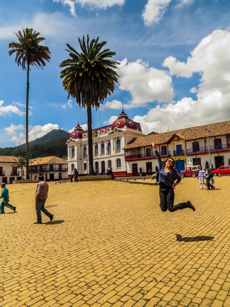 Plaza principal de Zipaquirá con palmeras, piso de ladrillo y edificios coloniales con techos de teja